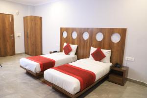 Un dormitorio con dos camas con almohadas rojas y blancas. en Hotel Cymbal -Sector 31 Gurgaon, en Gurgaon 34 fotos más