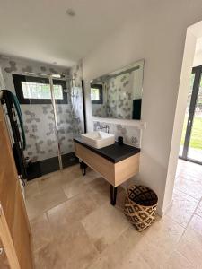 a bathroom with a sink and a mirror at Maison dans les bois in Lacquy +30 photos