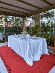 una mesa con un mantel blanco sobre una alfombra roja en Villa Laura, en Lierna