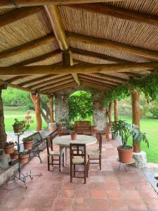 a patio with a table and chairs under a wooden pergola at Finca los churquis in Tumbaya +8 photos