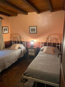 a bedroom with two beds and a lamp on a table at Finca los churquis in Tumbaya