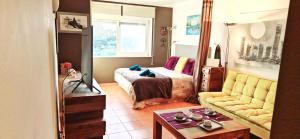 a bedroom with a bed and a couch and a table at Studio on Maria Luisa Beach Wifi Parking Swimming Pool in Olhos de Água +27 photos