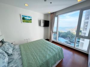 北芭堤雅The Palm Wongamat - 2BR Luxury Beachfront Suite - Ocean View的一间带床和大窗户的卧室 更多23张照片