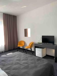 a room with a bed and a desk and two chairs at Villa Sicilia in Yaremche