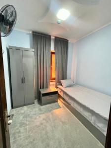 サマルカンドにあるGuesthouse Asteriya Гостевой домの小さなベッドルーム(ベッド1台、キャビネット付)