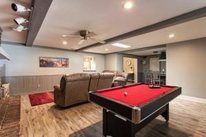 a living room with a pool table and leather chairs at The Flo's House in Tampa