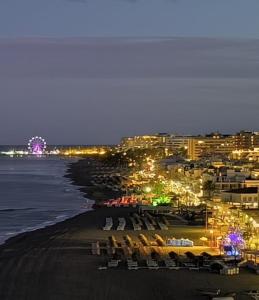 a view of a beach at night with a city at Castillo Santa Clara in Torremolinos