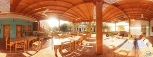 a room with tables and chairs and a wooden ceiling at Jowhara Hotel in Dahab