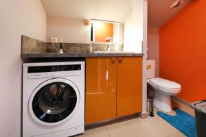 una lavadora en un baño con inodoro en T2 duplex avec vue imprenable, en Xonrupt-Longemer