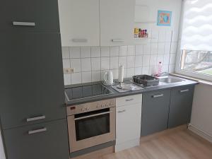a small kitchen with a stove and a sink at Ferienwohnung Leuchtturm mit E-Bike Verleih in Wilhelmshaven