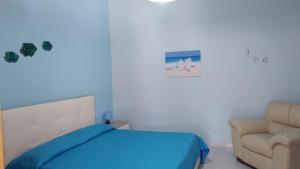 a bedroom with a bed and a chair at La Rosa dei Venti B&B in Chia