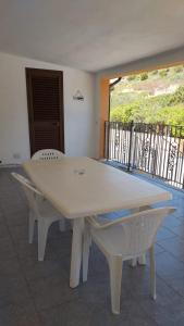a white table and chairs in a room with a balcony at La Rosa dei Venti B&B in Chia
