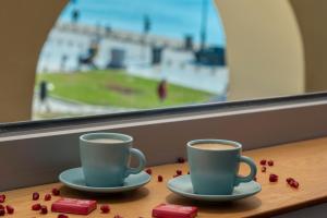 two cups of coffee on a table in front of a window at Square Elegant Suites in Thessaloniki +33 photos