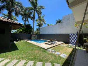 a backyard with a pool and palm trees at Espaço Festa Campos in Campos dos Goytacazes