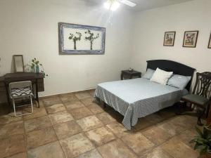 een slaapkamer met een bed, een tafel en een stoel bij Finca El Fraile in Monterrey +16 foto's