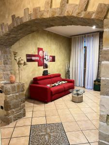 a red couch in a living room with a brick wall at Il Tortellino Quasi in Centro Elegant Apartment in Modena