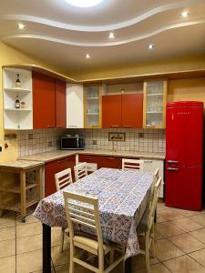 a kitchen with a table and a red refrigerator at Il Tortellino Quasi in Centro Elegant Apartment in Modena +26 photos