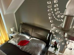 a bedroom with a black bed with a red pillow at Dom nad jeziorem Miedwie, Zieleniewo in Zieleniewo