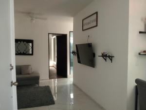 a living room with a television on a wall at Cozy apartment & pool in Villa de Alvarez