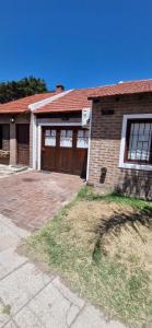a brick house with two garage doors and a driveway at El viejo garage in Mar de Ajó +4 photos