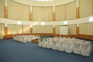 Cette grande chambre comprend des rangées de tables et de chaises. dans l'établissement Hotel Expo, à Yunusobod