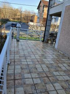 a patio with a white railing and a fence at SD Apartmani Stan Na Dan in Smederevo +1 photo