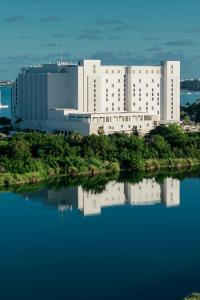 a large white building next to a body of water at The St. Regis Aruba Resort in Palm-Eagle Beach