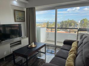 Una sala de estar con un sofá y una ventana grande. en Nautica Luxe Apartments, en Lárnaca