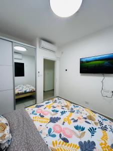 a bedroom with a bed and a large mirror at הפנינה השחורה in Mitzpe Ramon