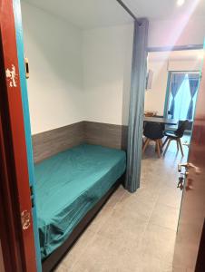 ein kleines Bett in einem Zimmer mit einem Tisch in der Unterkunft Mer et dune - Les Caravelles in Saint-Cyprien