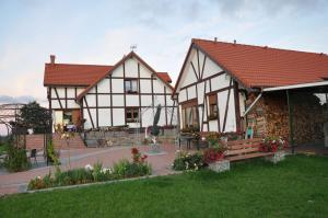 two white and brown houses with flowers in a yard at Apartamentypomorze in Białogóra