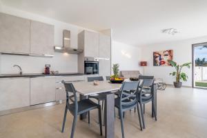 una cucina e una sala da pranzo con tavolo e sedie di Villa le Tarantine a Taurisano