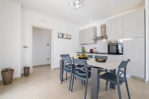 una cucina e una sala da pranzo con tavolo e sedie di Villa le Tarantine a Taurisano