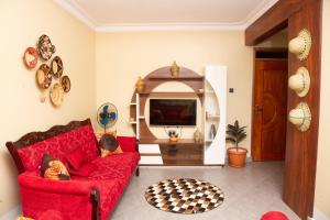 un soggiorno con un divano rosso e una TV di Kirungi Vacation Homes a Fort Portal