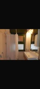 a bathroom with a shower and a sink and a mirror at Chira House in Santa Marinella +8 photos