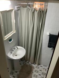 Un baño con lavabo y cortina de ducha. en Casa Serena Mar, en Balneario El Condor 16 fotos más