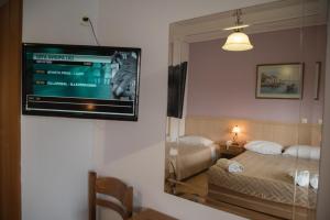 a room with a television on a wall with a bed at studio nufaro in Mytilene