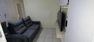 a living room with a blue couch and a television at Apto 2 quarto completo com vaga-proximo shopping contagem in Contagem