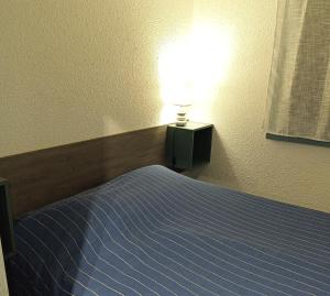 - une chambre avec un lit et une lampe dans l'établissement Logement plage, à Saint-Cyprien
