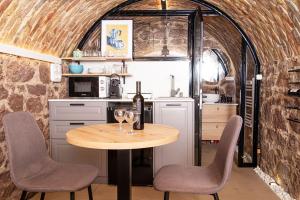 a kitchen with a table with two glasses of wine at Odu The Cellar in Alsóörs
