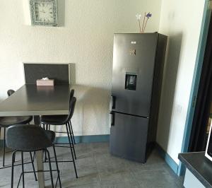 une cuisine avec une table et un réfrigérateur dans l'établissement Logement plage, à Saint-Cyprien