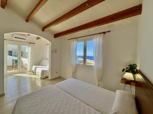 a bedroom with a bed and a view of the ocean at Villa Victor in Cala en Blanes +10 photos
