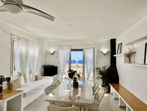 a white living room with a table and a couch at Villa Victor in Cala en Blanes