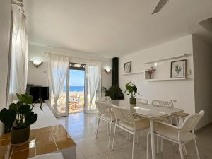 a dining room with a table and chairs and the ocean at Villa Victor in Cala en Blanes