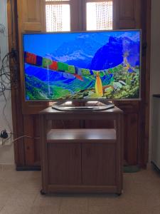 TV de pantalla plana en la parte superior de un soporte de madera en Casa Serena Mar, en Balneario El Condor