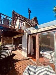 una casa con una puerta de cristal en una cubierta en J Bay Surf Villa, en Jeffreys Bay