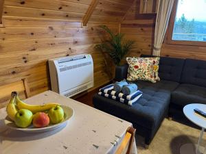 a living room with a couch and a bowl of fruit on a table at Villa Lena Nagymaros in Nagymaros
