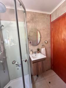 ein Badezimmer mit Waschbecken und Dusche in der Unterkunft Cabaña estilo mediterránea in Pucón + 12 Fotos