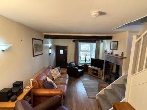 a living room with a couch and a fireplace at May Cottage in Tideswell