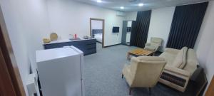 Motel beyza في السليمانية: غرفة معيشة مع أريكة وكرسي